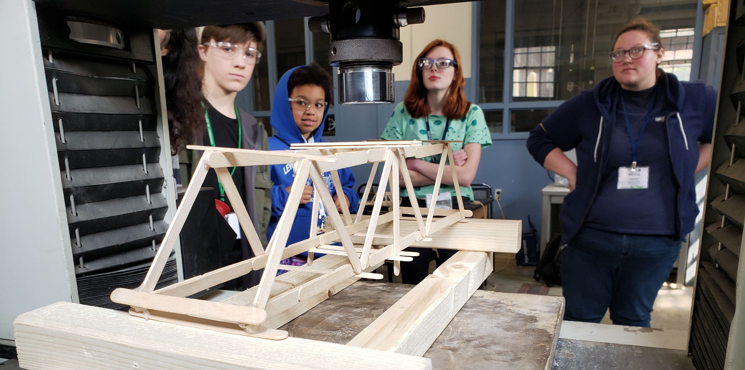 4H students testing their bridge using a hydraulic actuator